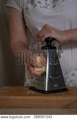 Womens Hands Rub Cheese On A Metal Grat