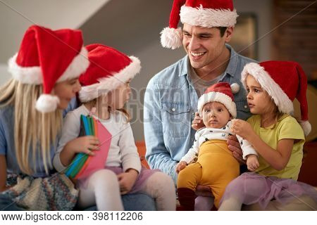 Happy parents spening Christmas time together with their kids; Family holiday concept