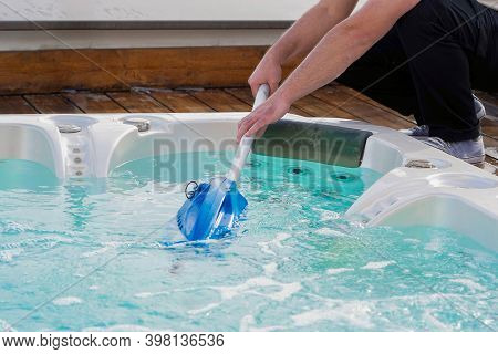 View Of The Open Working Hot Tub. Pool Cleaner During His Work. Caucasian Hotel Staff Worker Cleanin