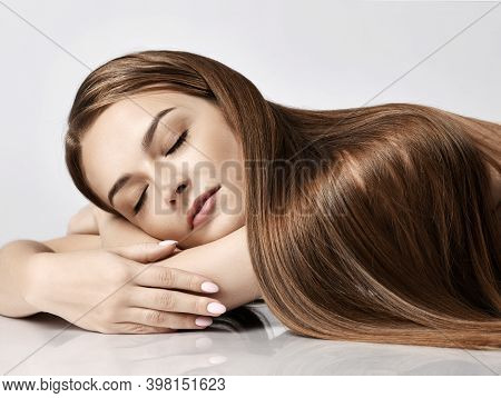 Portrait Of Young Pretty Woman Model With Silky Long Straight Hair Lying And Relaxing With Eyes Clos