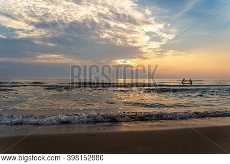 Children Playing In The Lake At Sauble Beach Ontario Canada At Sunset.