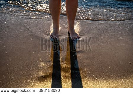 Bare Feet In The Waves At The Beach