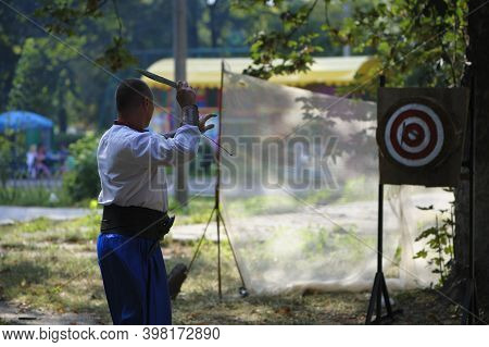 A Man Is Ready For Throwing Knife To The Target On Competition.