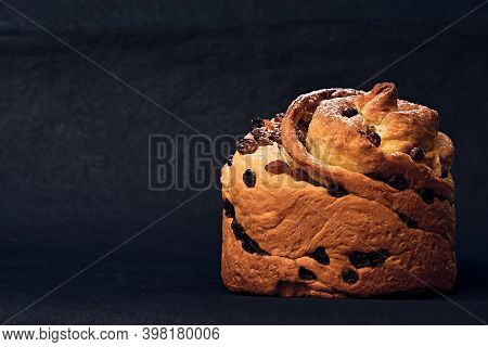 Christmas Panettone With Raisins, Sprinkled With Powdered Sugar. Craffin Isolated On A Dark Backgrou