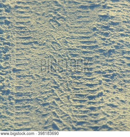 Tire Tracks Left In The Snow On A Bright Sunny Day. The Concept Of Snow Removal, Ski Resorts, Active