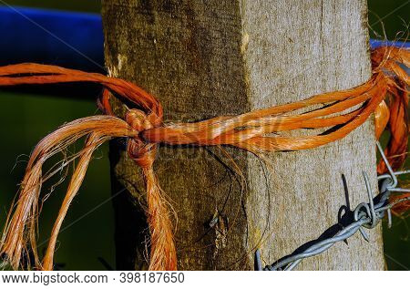 Orange Rope And Barbed Wire On Gate Post To Prevent Unauthorised Entry.