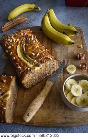 Wholegrain Banana Bread Freshly Sliced On A Cutting Board, With Banana, Cinnamon And Nuts. Bake Shop