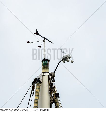 Top Of The Mast Of A Sailboat With Wind Indicator, Lanterns, Antennas And Other Instruments.