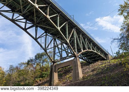 Hillside With Concrete Supports Of An Overhead Arch Bridge, Fall Season With Blue Sky, Horizontal As