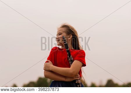 Young Attractive Girl Playing Clarinet, Ebony In Fall Park