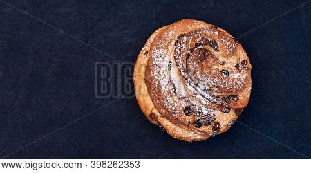 Christmas Panettone With Raisins, Sprinkled With Powdered Sugar. Craffin Isolated On Dark Background