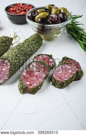 Traditianal Fuet Sausage In Herbs With Ingredients On White Surface