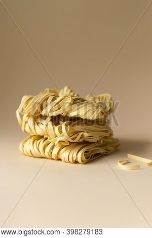 Natural Dry Egg Noodles On A Brown Background. Vertical Orientation. Copy Space.