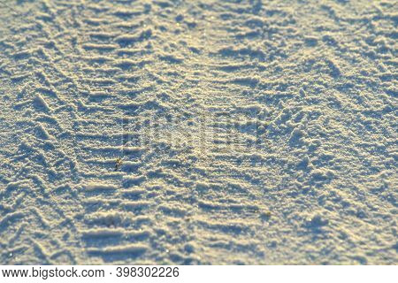 Tire Tracks Left In The Snow On A Bright Sunny Day. The Concept Of Snow Removal, Ski Resorts, Active