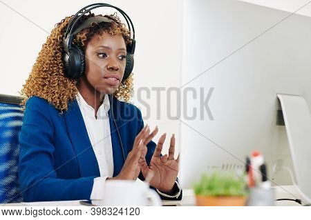 Pretty Young Black Female Technical Support Opearator In Headset Answering Phone Call From Client