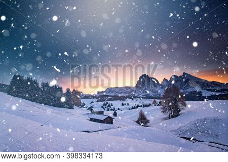 Small cottage in magic sunset in Dolomite mountains, Alpe di Siusi, Italy in winter
