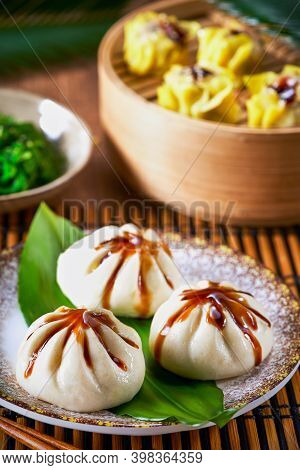Dumplings Set Xiao Long Bao And Shao Mai In Bamboo Steaming Basket And Chopsticks On Bamboo Mat. Sel