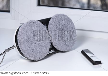 Downside Of Vacuum Cleaner Robot For Washing Glass Window On White Windowsill. Robot Assistant At Ho