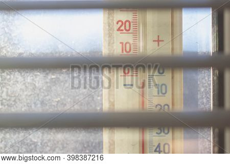 A Thermomert Outside The Window Shows The Temperature Outside The Window Below Zero Degrees Celsius.