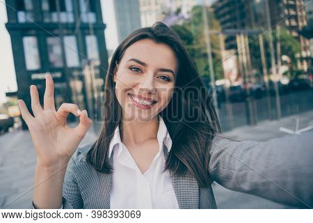 Photo Of Joyful Pretty Businesswoman Wear Formalwear Suit Jacket Make Selfie Okay Sign In Outdoors C