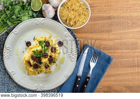 A Typical Portuguese Dish Of Shredded Cod, With Potato Straw, Mixed Egg And Dark Olives. On A Wooden