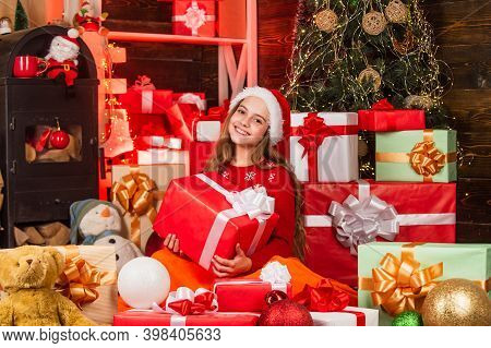 Smiling Shop Assistant. Kid In Santa Hat With Many Gift Boxes. Successful Shopping On Xmas Market. D