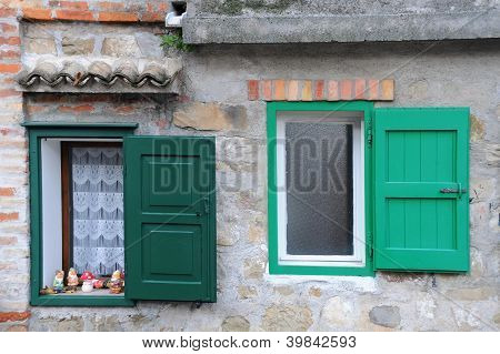 Duas janelas com persianas verdes