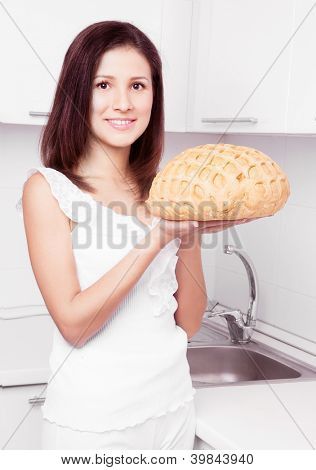 schöne junge Frau mit Brot in der Küche zu Hause