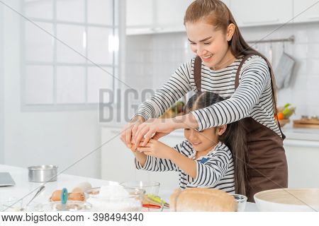 Mother And Daugther Is Breaking Egg To Make Bakery In Kitchen Together, For Family Love Activity Con
