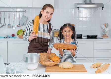 Mother And Children Is Showing Bread And Dough In The Kitchen For Family Activity Togetherness Conce