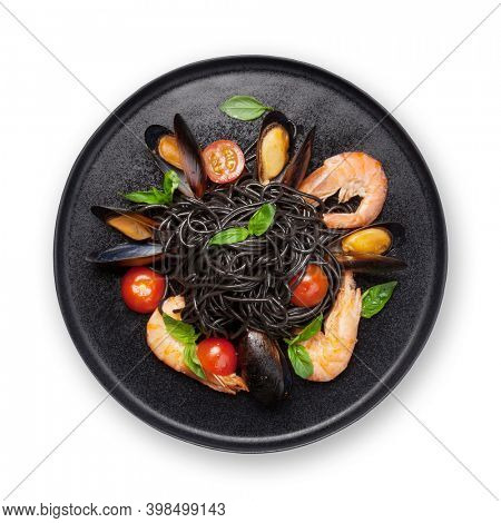 Black squid ink spaghetti pasta with seafood, tomatoes and basil. Isolated on white background. Top view flat lay