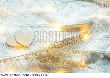 Two Wooden Hearts Mock Up On A White Knitted Cozy Background With Lights Of Garlands And Dry Grass-w