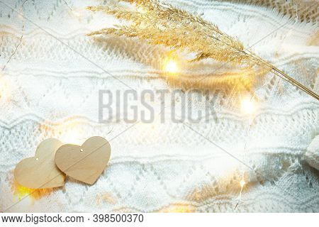 Two Wooden Hearts Mock Up On A White Knitted Cozy Background With Lights Of Garlands And Dry Grass-w