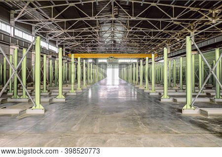 Warehouse Of Engineering Plant Shop With Yellow Overhead Crane. Empty Storage Areas Of New Metalwork