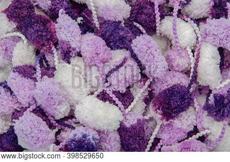 Hanks Of White, Violet And Purple Pompons. Knitter Background. Top View.