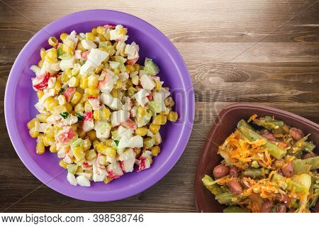 Crab Salad On Purple Plate With Vegetaible Salad Top View. Crabs Salad On Brown Wooden Background
