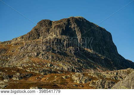 Mount Bitihorn In Norway With Blue Skies In The Background.