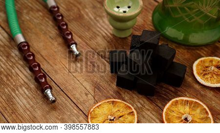 Coals For Hookah On Wooden Background With Dry Oranges And Bowl. Place For Text