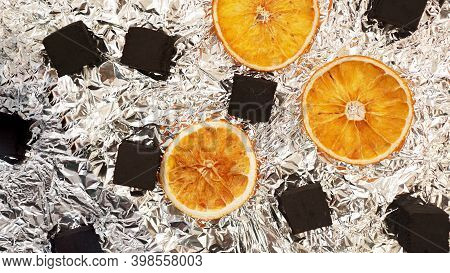 Coals For Hookah On Foil Background With Dry Oranges - Top View