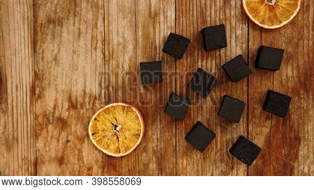 Coals For Hookah On Wooden Background With Dry Oranges - Top View