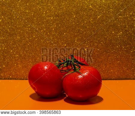 Round Red Tomatoes On A Branch With A Colored Background And Water Drops