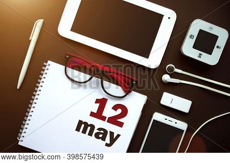 May 12nd. Day 12 Of Month, Calendar Date. Office Workplace With Laptop, Notebook, Office Supplies An