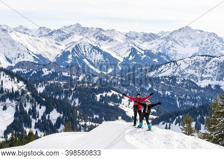 Senior Couple Is Snowshoe Hiking In Alpine Snow Winter Mountains Panorama. Happy Successful People W