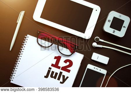 July 12nd. Day 12 Of Month, Calendar Date. Office Workplace With Laptop, Notebook, Office Supplies A