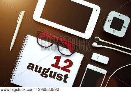 August 12nd. Day 12 Of Month, Calendar Date. Office Workplace With Laptop, Notebook, Office Supplies