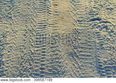 Tire Tracks Left In The Snow On A Bright Sunny Day. The Concept Of Snow Removal, Ski Resorts, Active