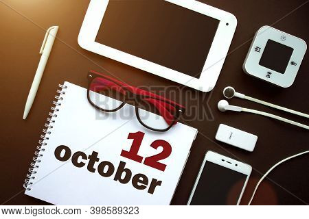 October 12nd. Day 12 Of Month, Calendar Date. Office Workplace With Laptop, Notebook, Office Supplie