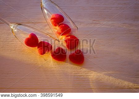 Marmalade Red Hearts And Two Glasses Of Champange On Wooden Background With Sunlight. Background For