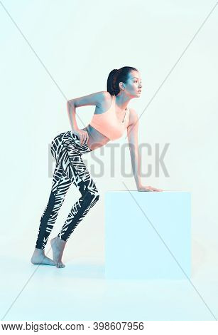 Fitness Female Posing In Sport Clothes In Neon Light. Fit Young Model With Perfect Body Shapes. Heal