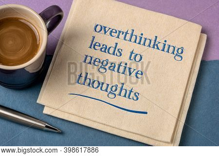 Overthinking leads to negative thoughts - handwriting on a napkin with a cup of coffee, procrastination, mindset and personal development concept